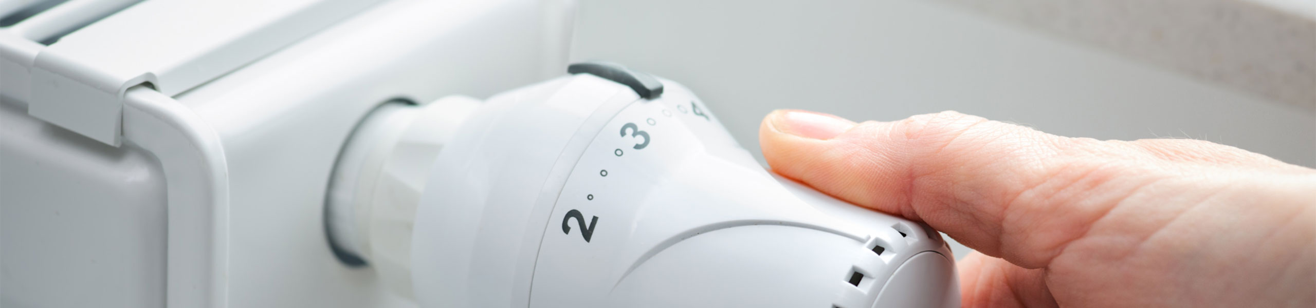 Hand an einem Heizungsthermostat