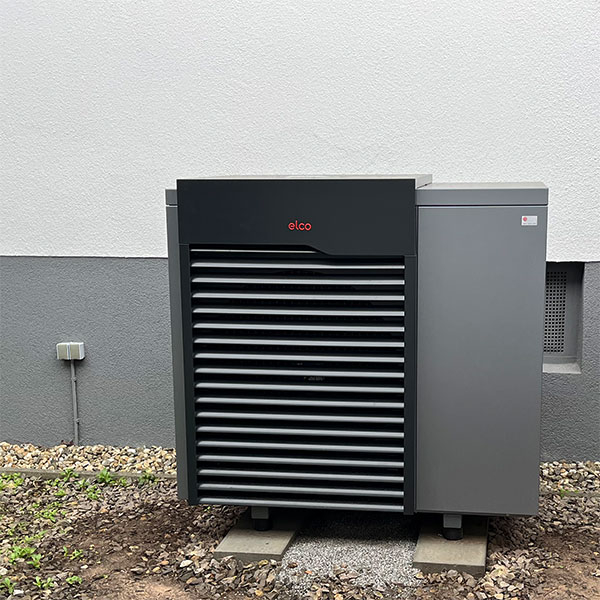 Wärmepumpe vor einem Wohnhaus